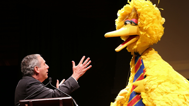 Harvard President Lawrence Bacow and Big Bird on stage