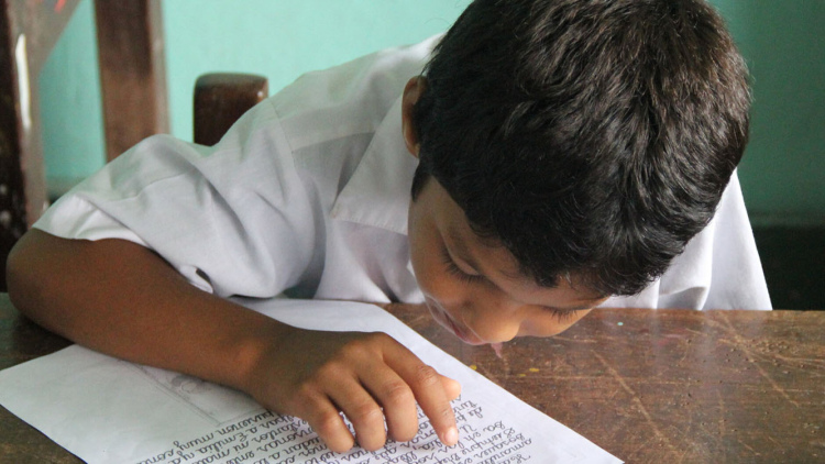 Peruvian boy at desk reading