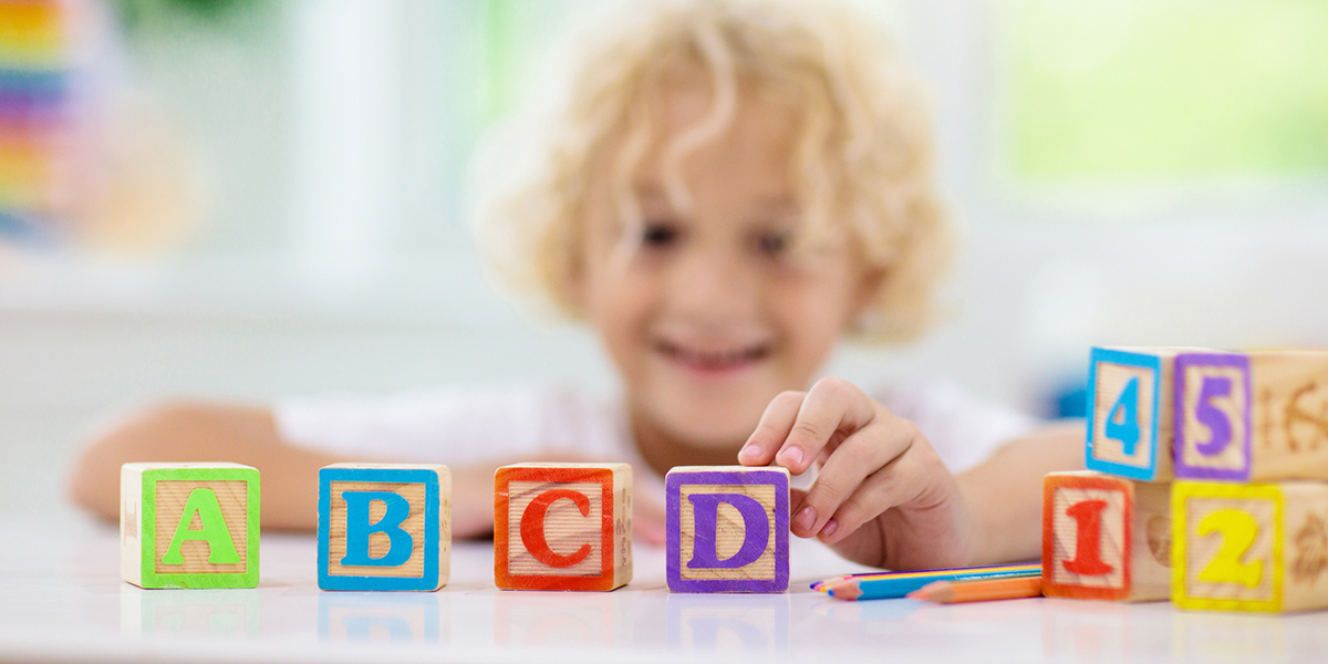 Child playing with wood letter blocks