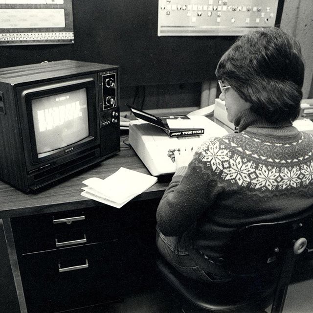 Black and white photo of woman on old computer