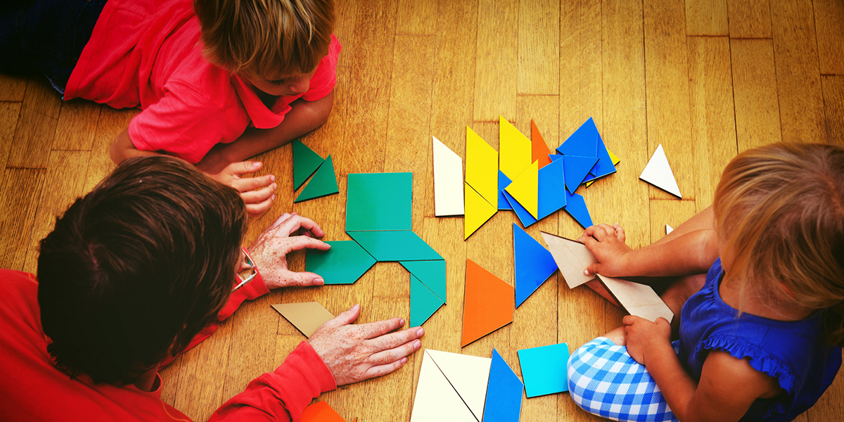 Preschoolers doing puzzle on floor