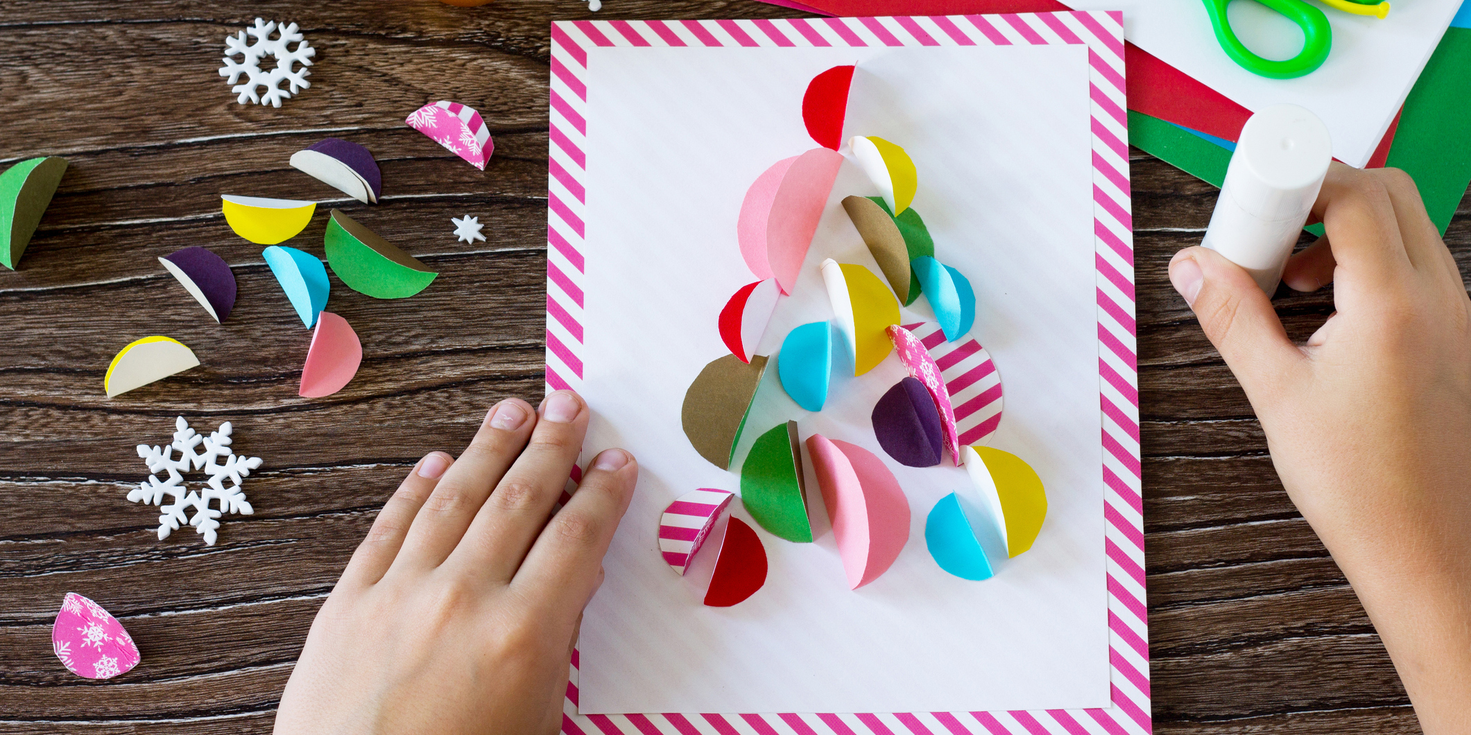 Child's hands making a card out of construction paper
