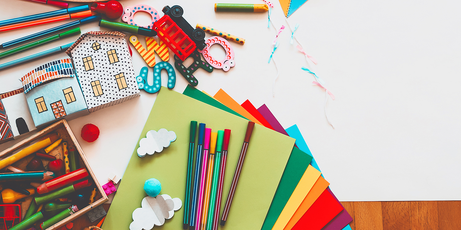 Children's art and buidling materials layed out on floor