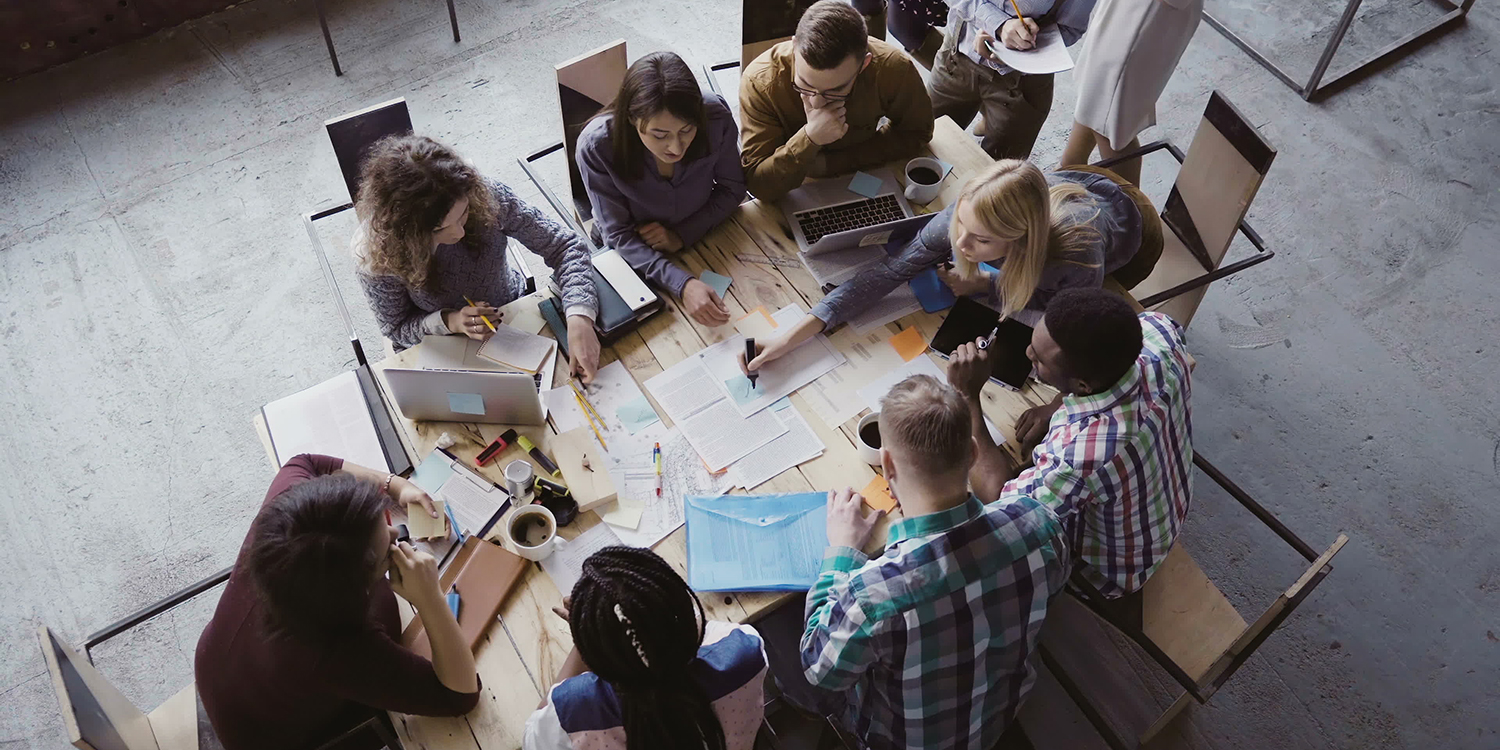 a group of college students, seen from above, working together around a table