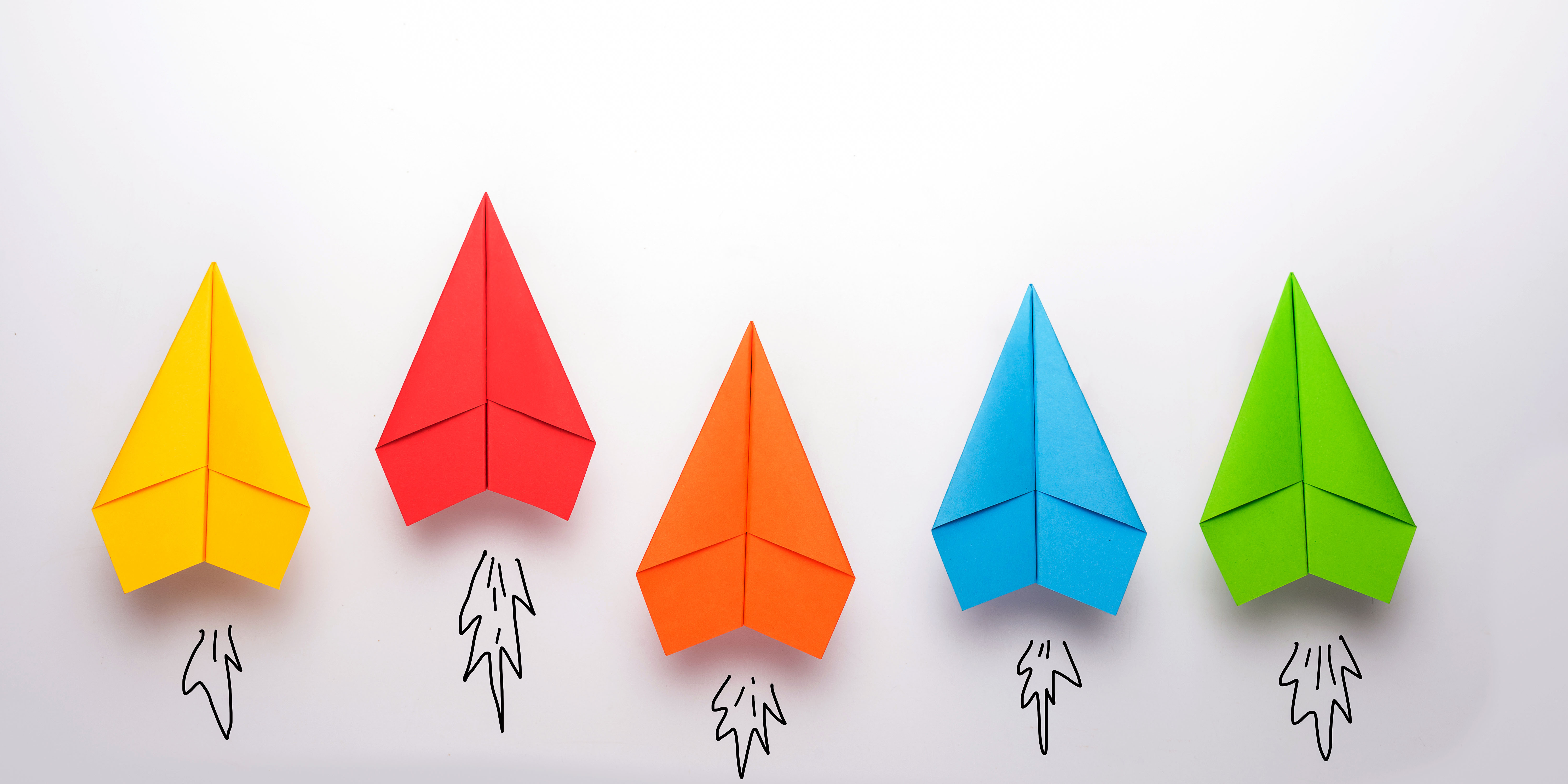 colorful paper airplanes flying upward