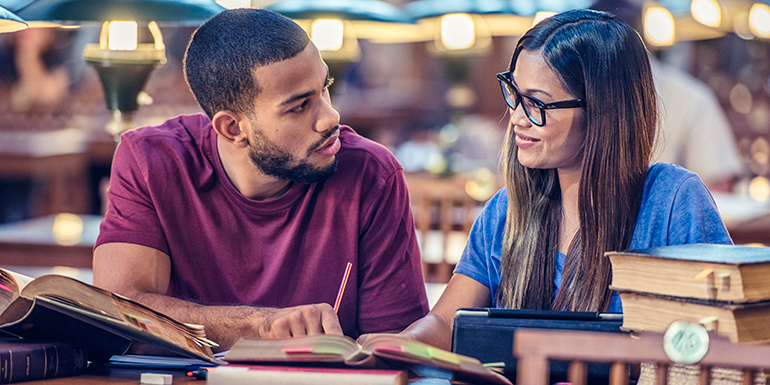 Male and female college student studying in library
