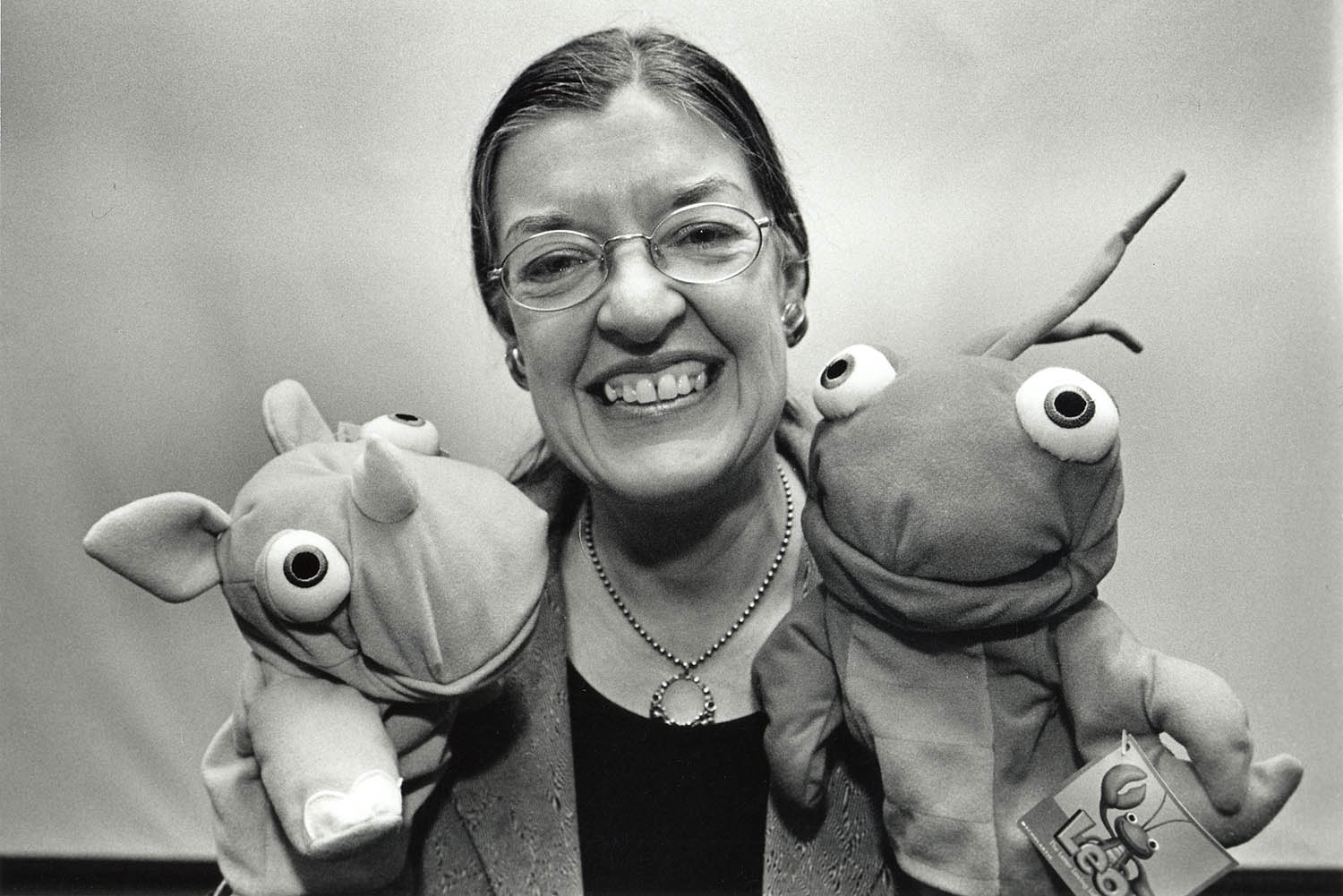 Black & white photo of Catherine Snow with puppets on hands