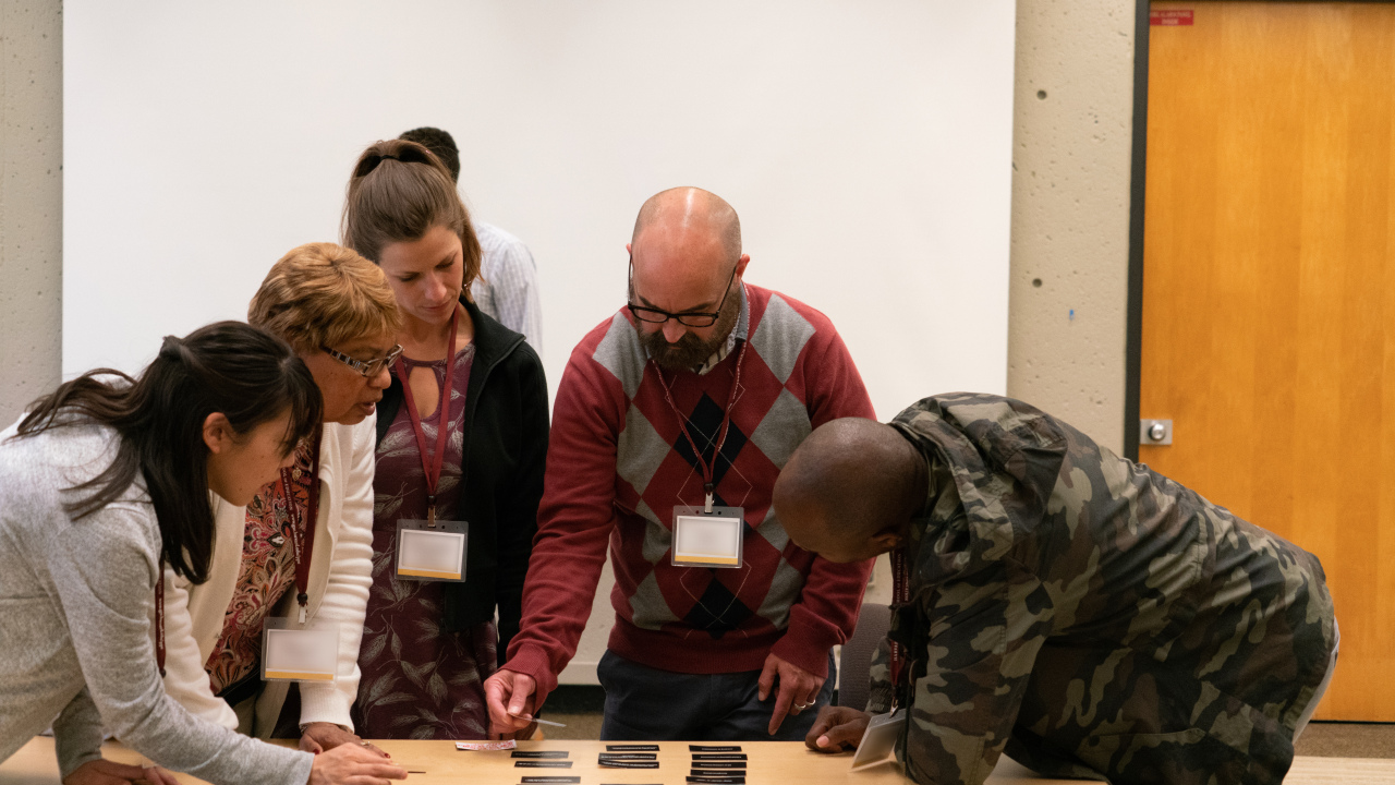 Group of educators collaborate over table.
