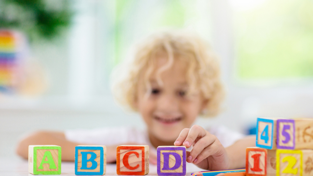 Child playing with wood letter blocks