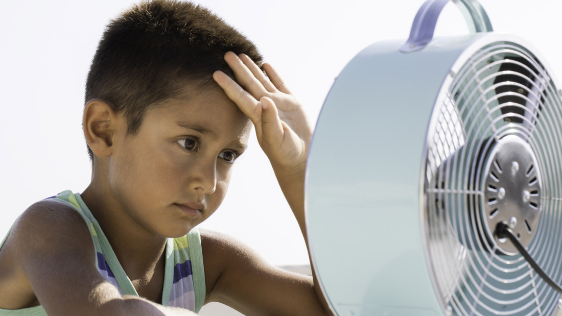 Overheated boy in front of fan