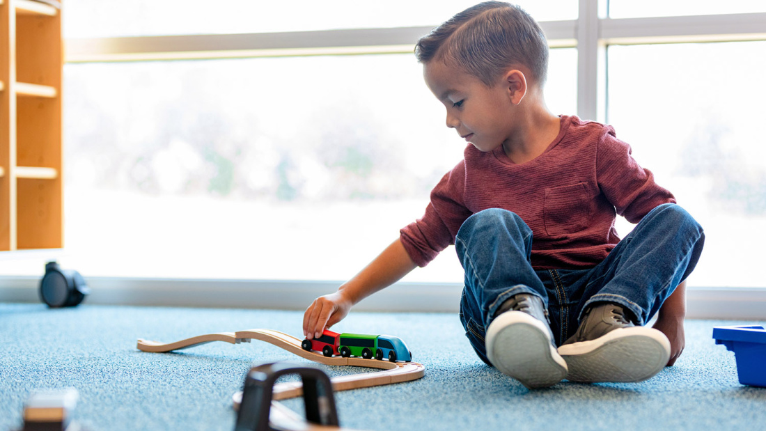 Boy playing alone with a train set