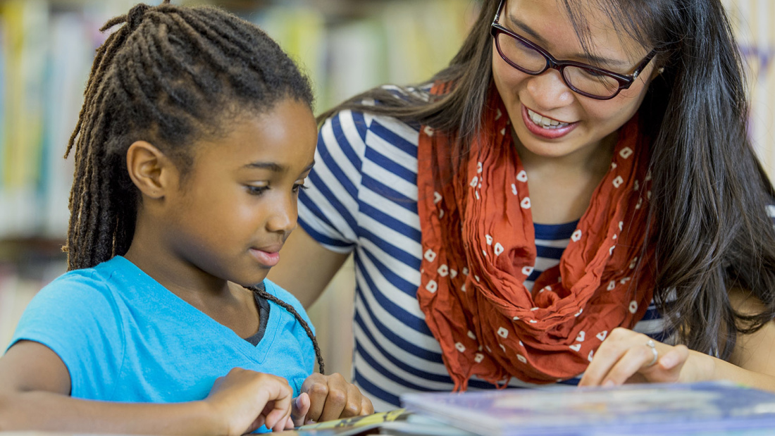 Teacher reading with a student