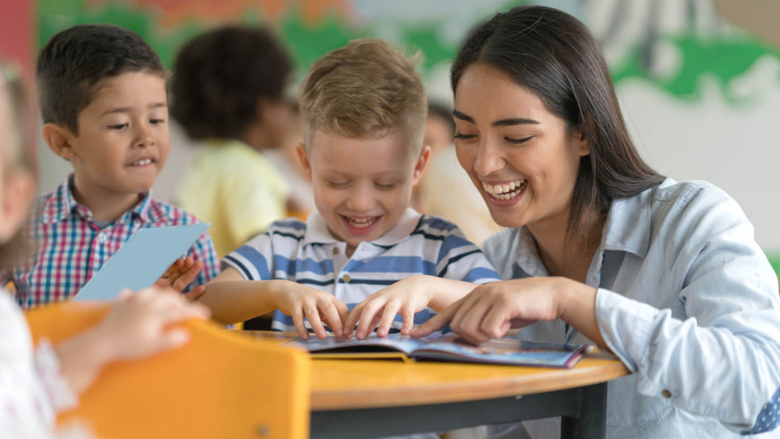Teacher reading with happy young student
