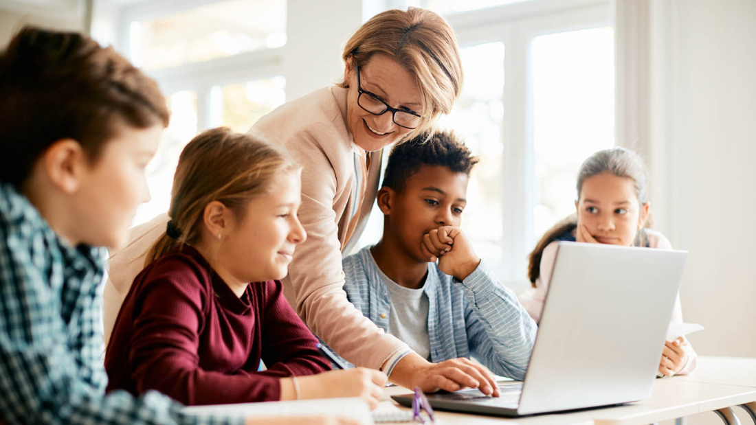 Stock image of teacher with group of young teen students