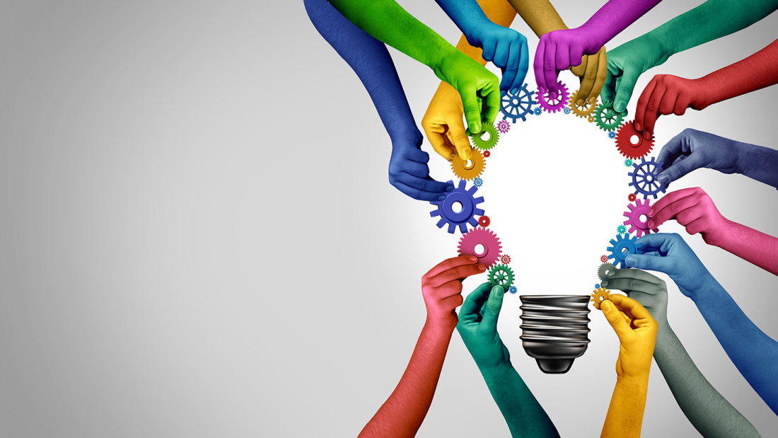 Colorful hands holding gears around a lightbulb