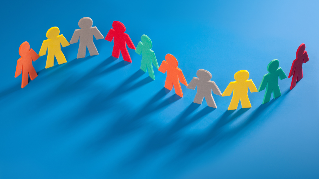 Multicolor paper chain of people on a blue background