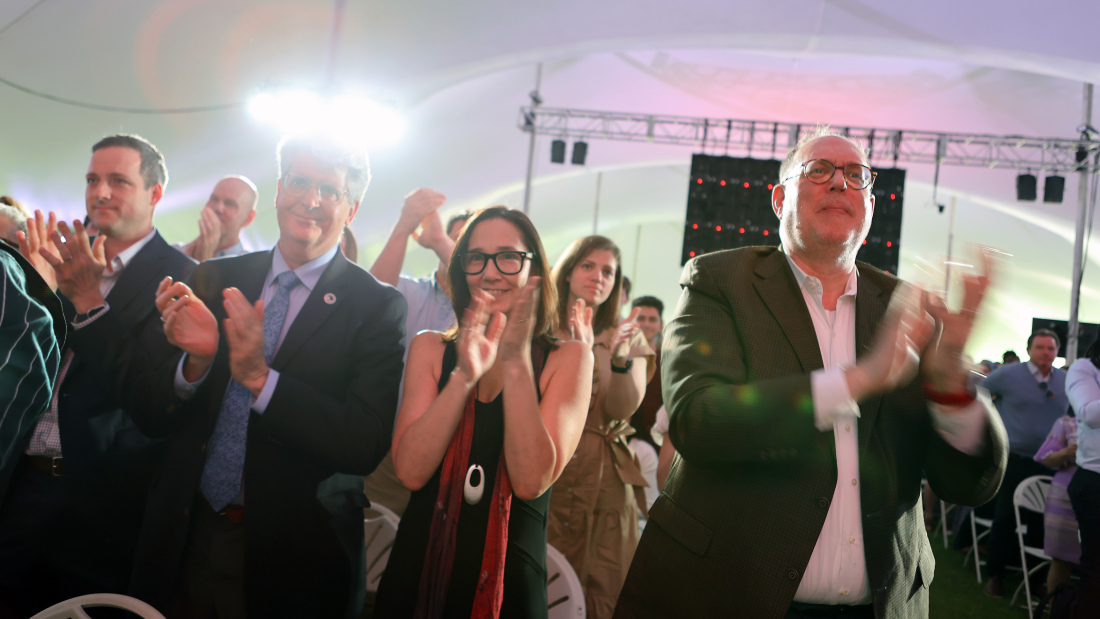 Faculty cheering under the tent