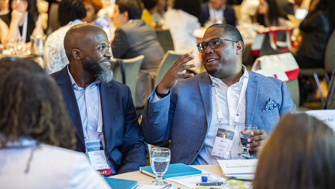 Ben Watson speaks with a peer at the EdRedesign Summer Institute