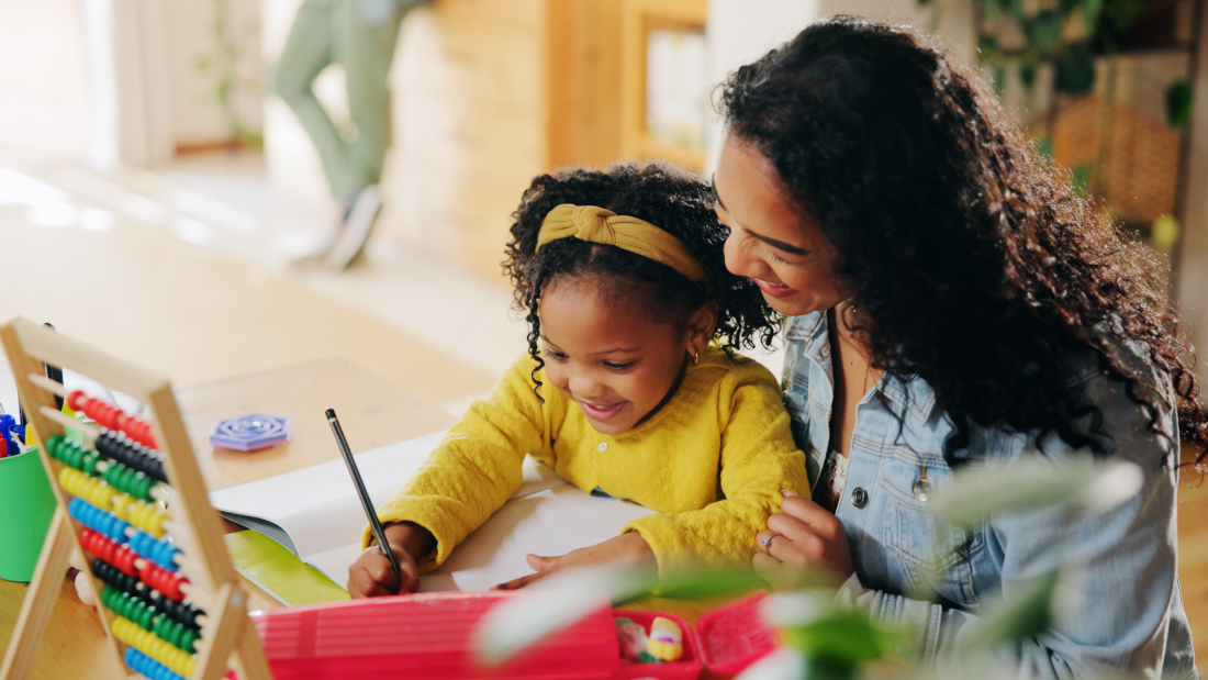 Mom helps young daughter with school work 