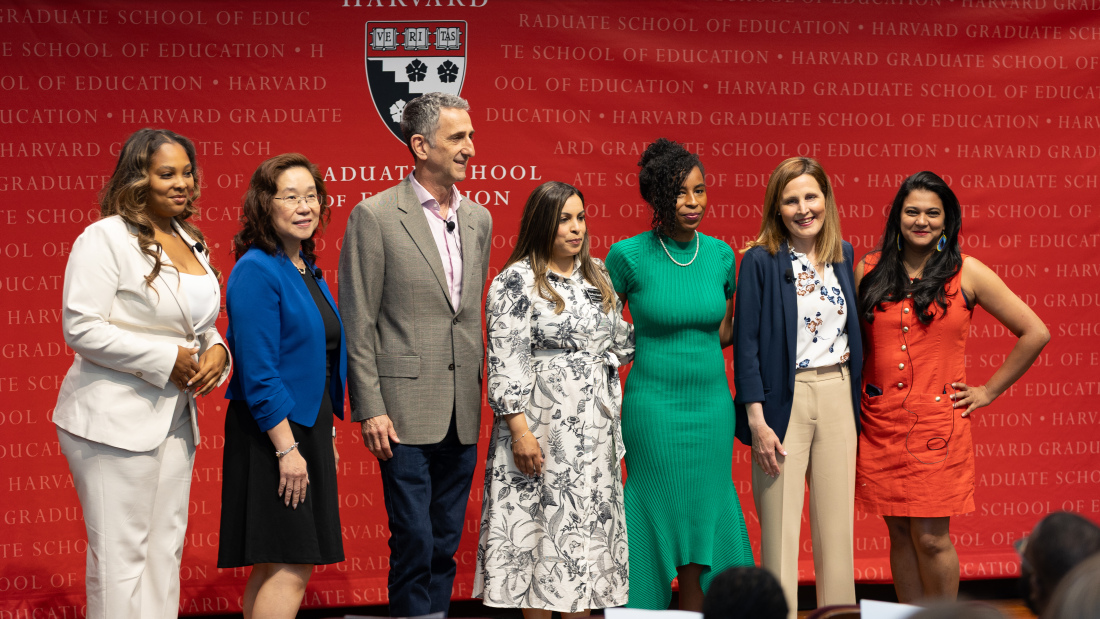 Several alums stand on stage at Alumni Day