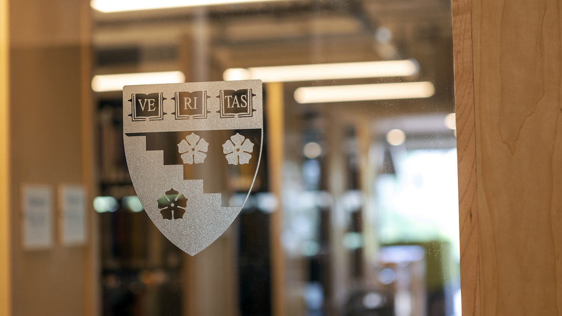 The Harvard Graduate School of Education crest on a glass wall in Gutman Library.