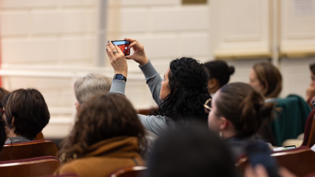 An attendee takes a photo of the forum's panelists