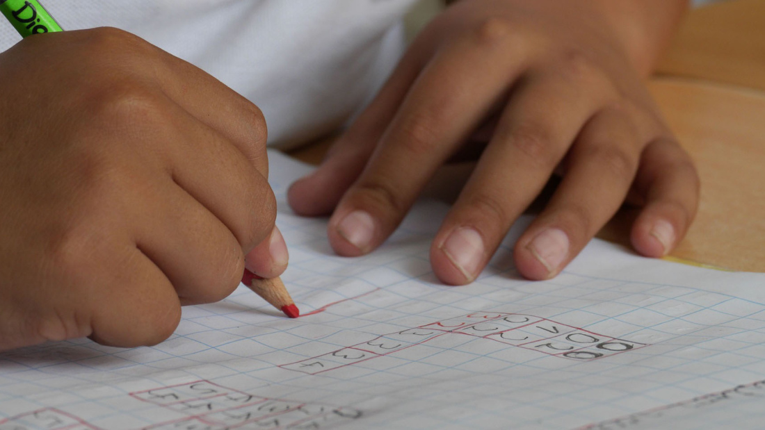 Child's hands doing math problem