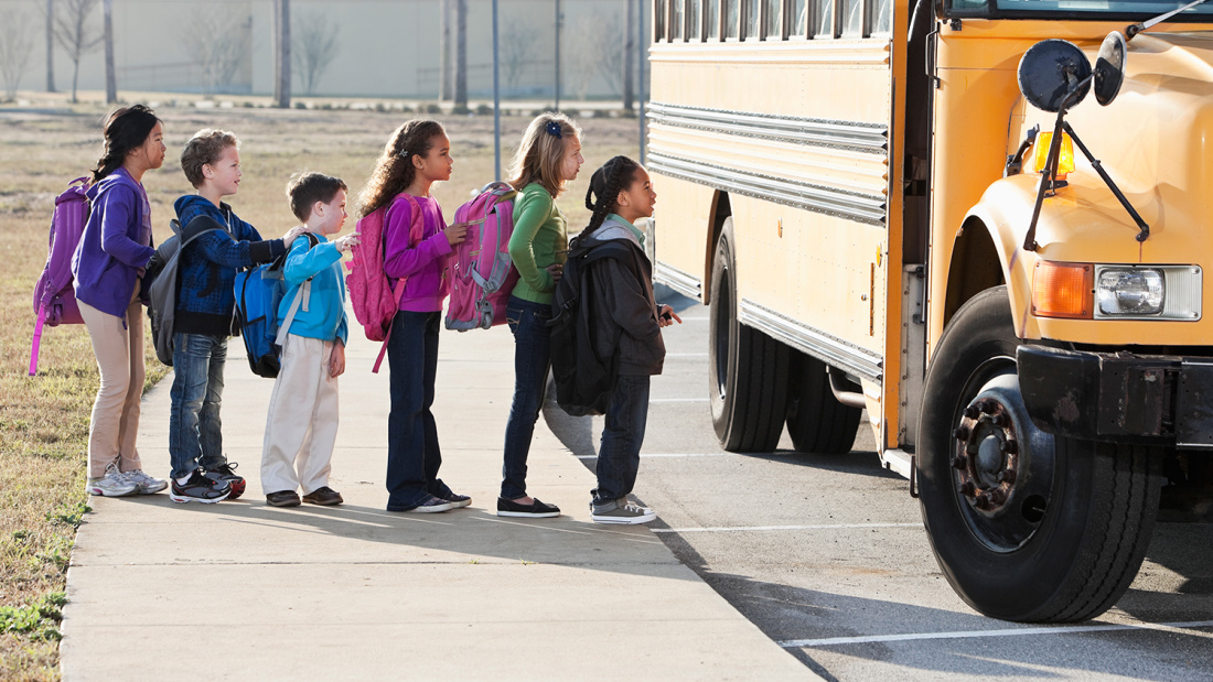 line of children getting onto a school bus