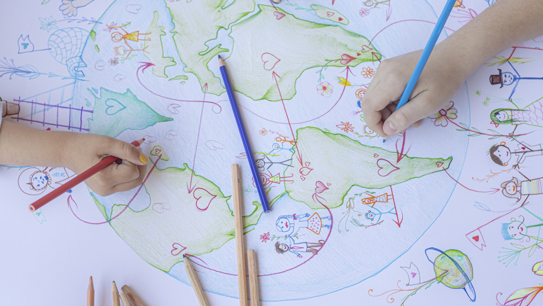 Children drawing a world map