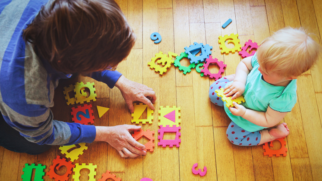 Baby playing on floor with parent