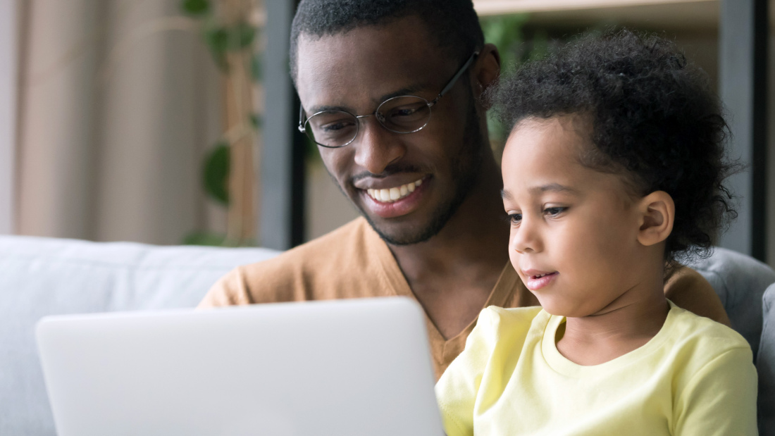 Parent looking at laptop with child