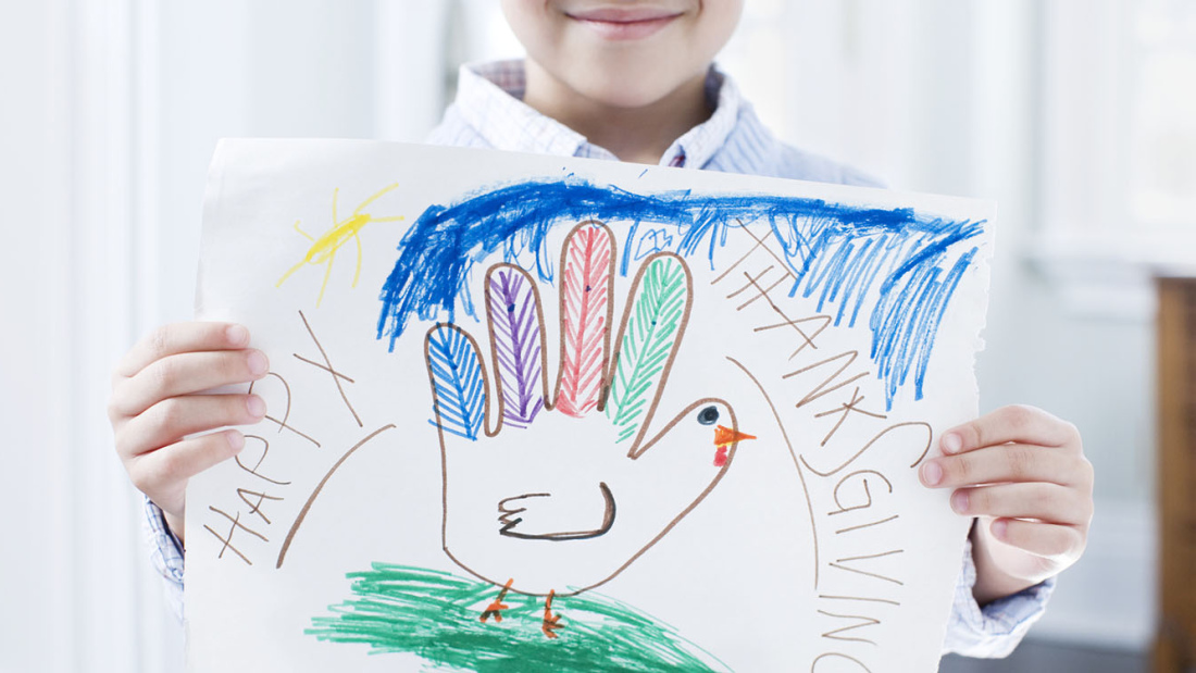 Smiling child holding a Happy Thanksgiving sign