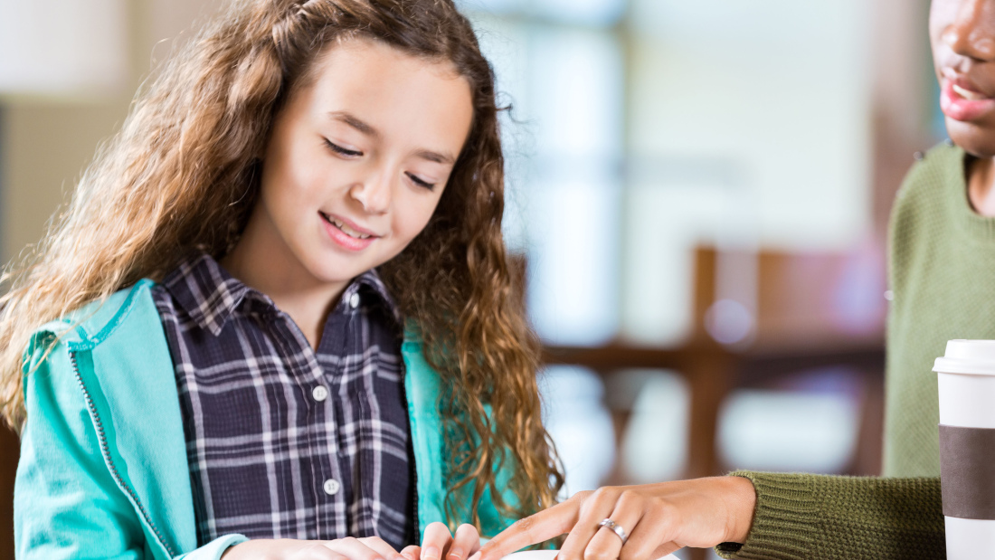 teacher helping girl with school work
