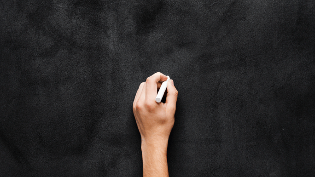 photo of a hand on a blackboard