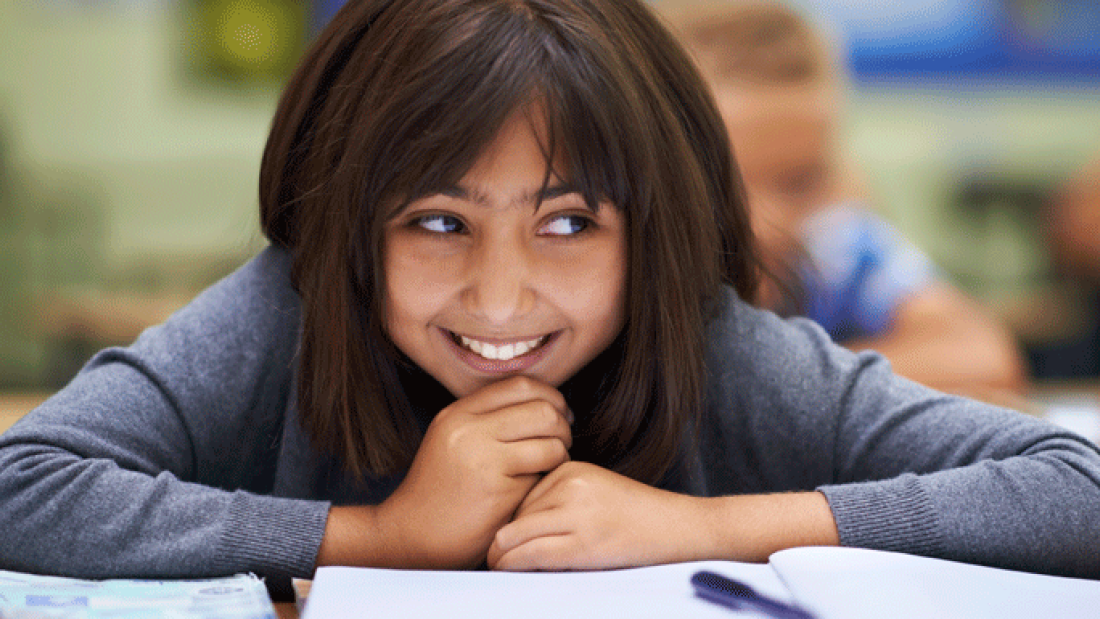 A photo of a female student smiling in class
