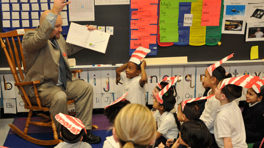 Lawrence receiver Jeff Riley reads to a group of students in Lawrence, Mass.