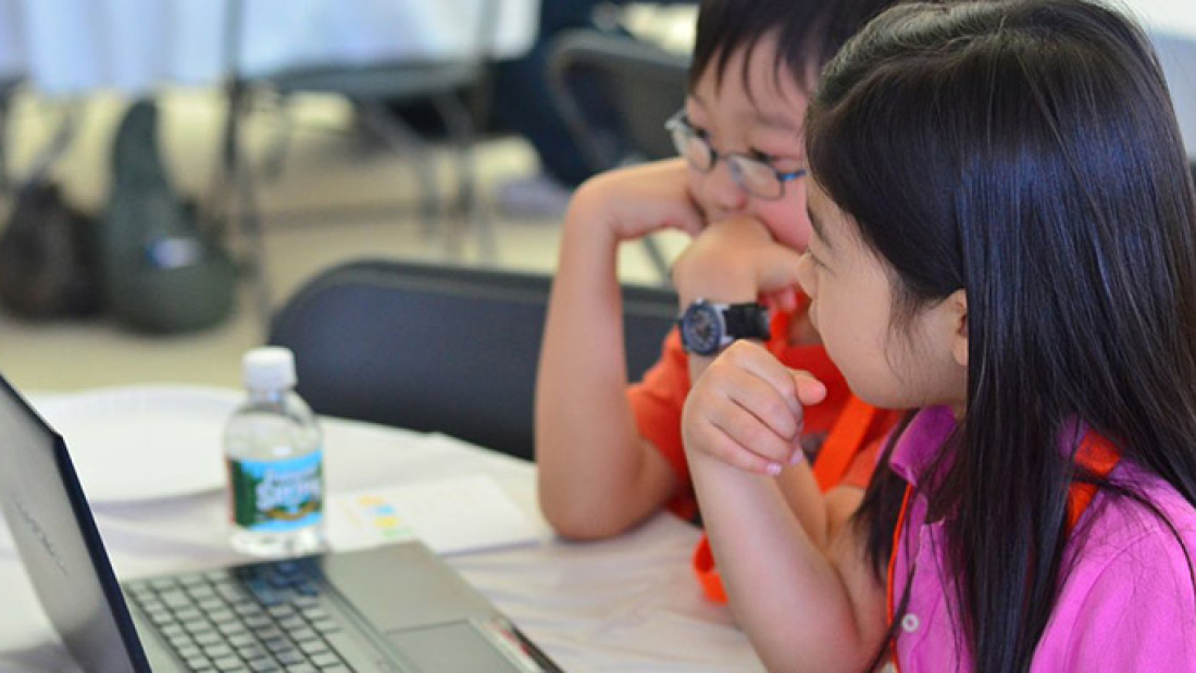 A photo of a boy and girl looking at a computer screen