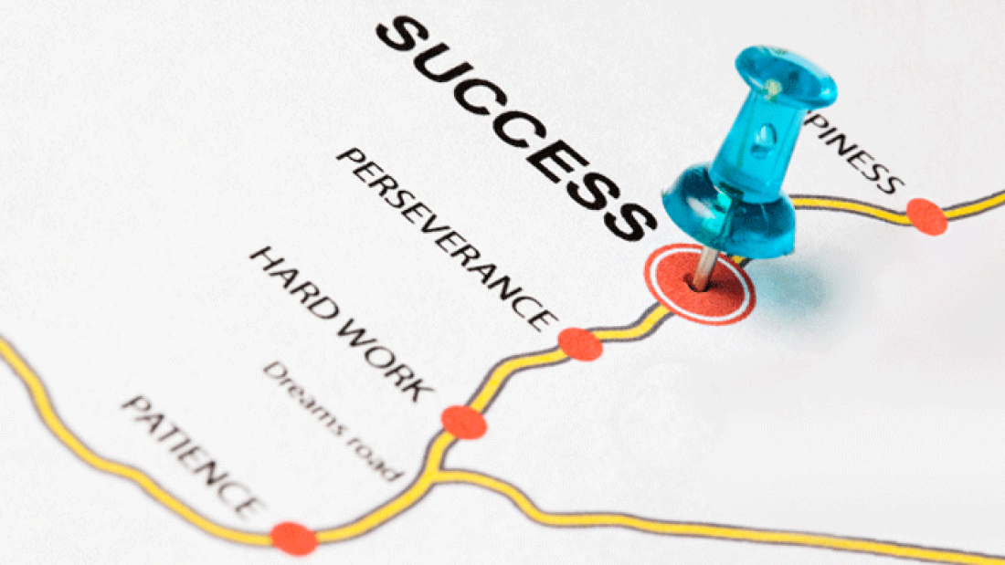 A road map with words that has a blue push pin on the word success