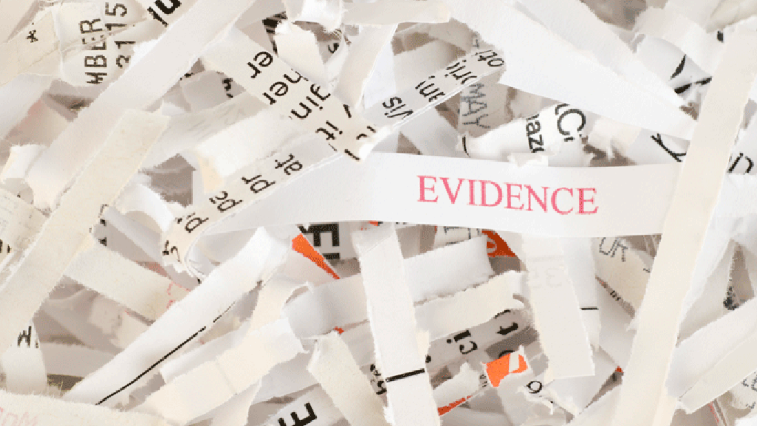 shredded paper with one piece that says evidence