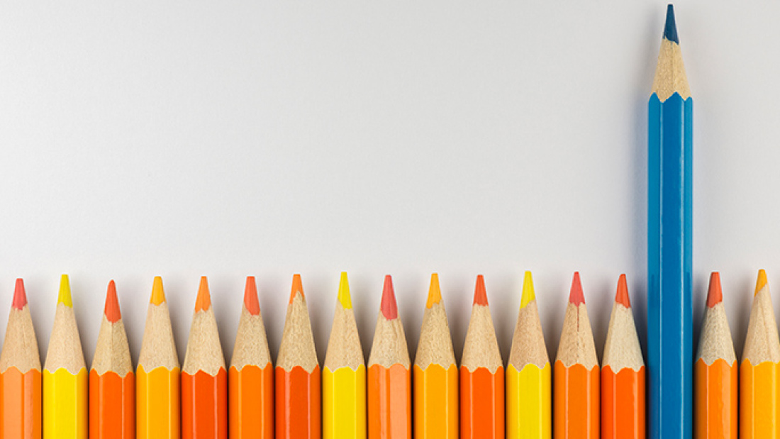 A row of alternating orange and yellow pencils, with one blue pencil sticking up