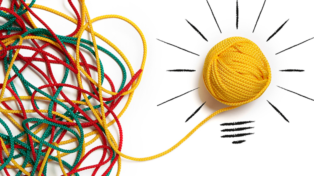 Messy strands of yarn coming together to form lightbulb