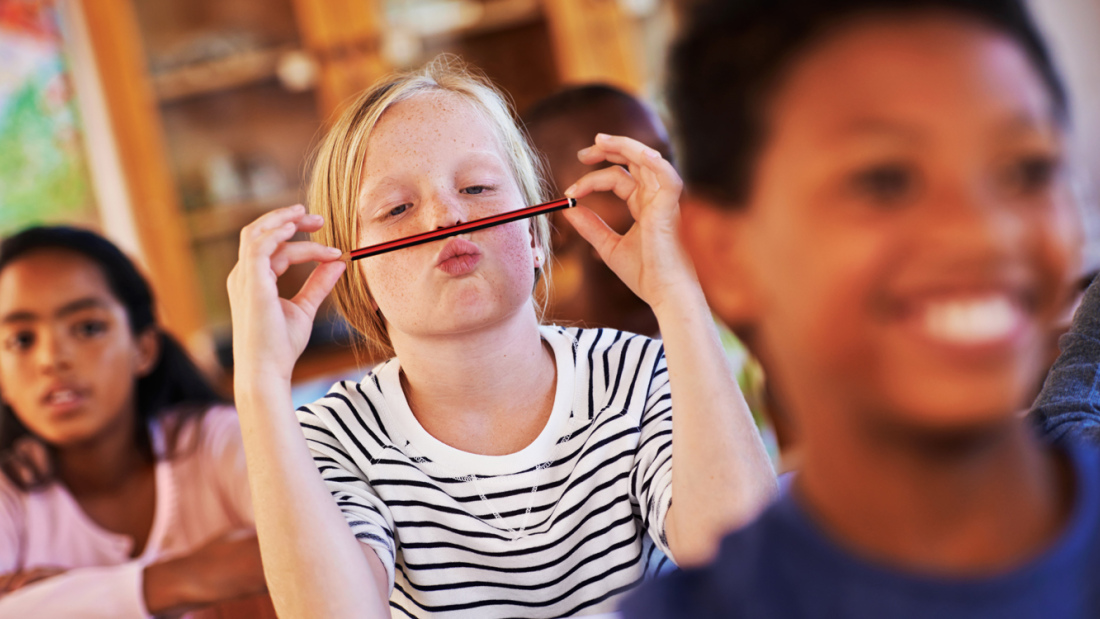 Photo of a girl goofing around with her pencil in class