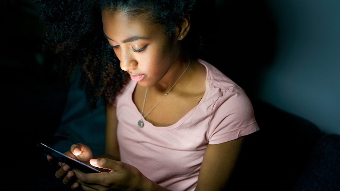 a young teenage girl staring at her phone