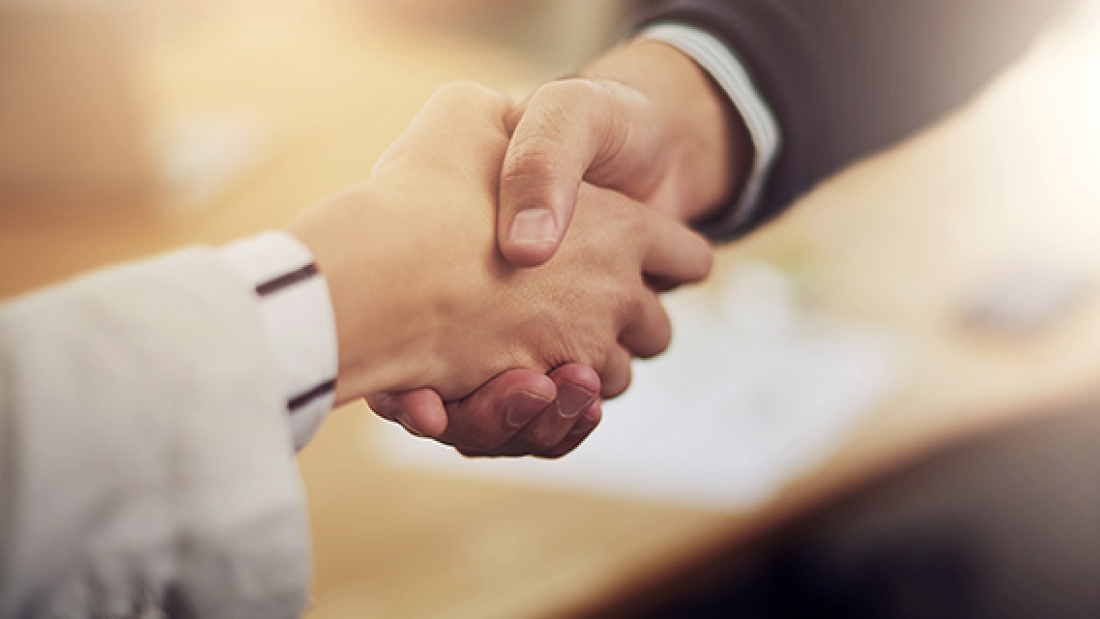 two adults shaking hands