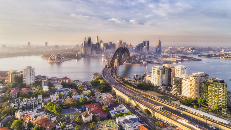 Bird's eye view of the Warringah freeway entering Sydney Harbour bridge along Kirribilli residential suburb on the North Shore, in view of the CBD with major landmarks.