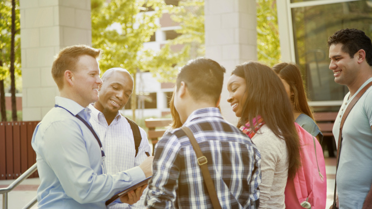 College recruiter or tour guide shows campus to potential students.