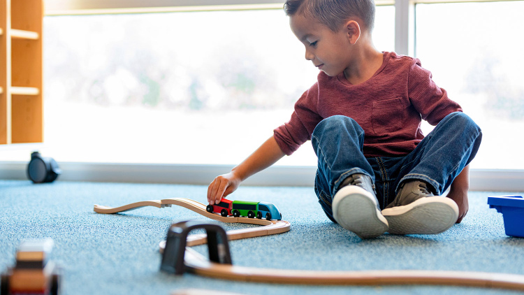Boy playing alone with a train set