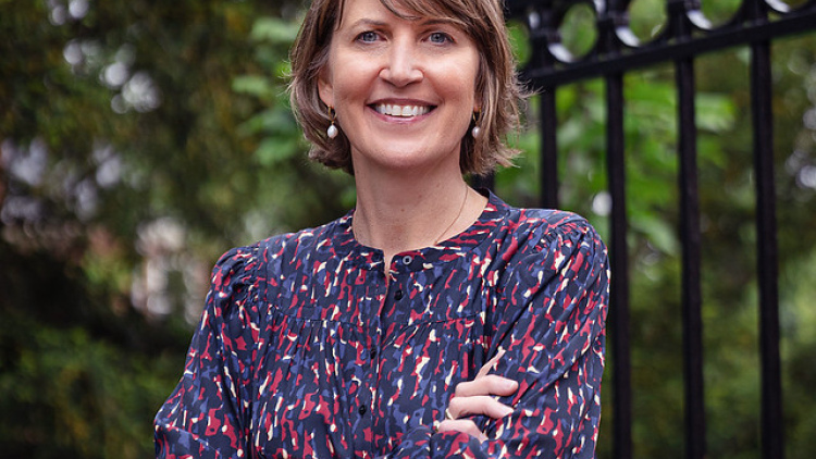 Jennifer Perry Cheatham's headshot; she is smiling outside with her arms folded