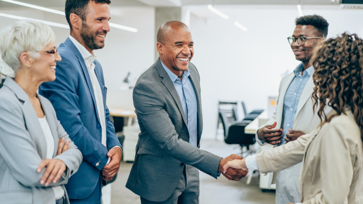 School leaders handshaking during a meeting in modern office.