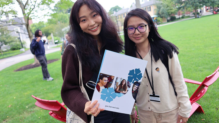 Two students holding HGSE brochure